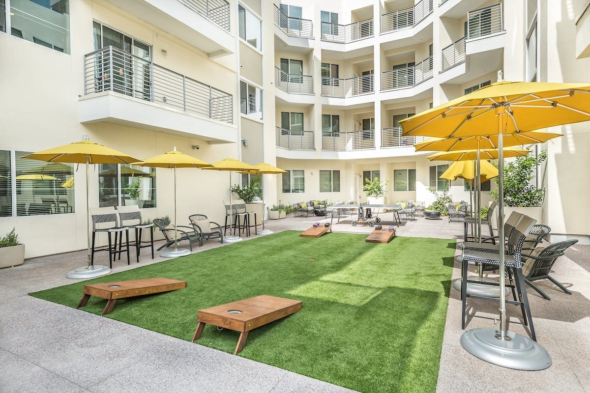 Apartments Phoenix - Outdoor Community Game Area with Seating, Bean Bag Toss and Ping Pong Table.